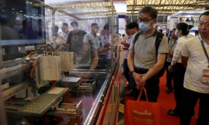 Khách tham quan xem các thiết bị sản xuất được trưng bày tại gian hàng của THK trong khuôn khổ hội chợ thương mại Semicon China ở Thượng Hải.