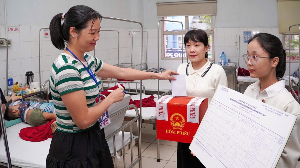 Thành viên tổ bầu cử mang hòm phiếu phụ đến từng phòng bệnh để phục vụ người nhà và bệnh nhân