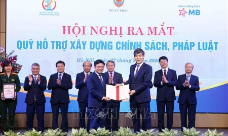 Đại diện các đơn vị đối tác trao văn bản bày tỏ ý định cam kết hỗ trợ cho Quỹ hỗ trợ xây dựng chính sách, pháp luật. Ảnh: TTXVN.