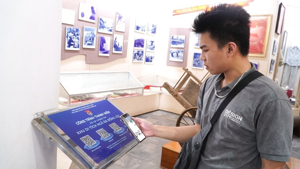 Du khách quét mã QR qua điện thoại để xem toàn bộ tư liệu lịch sử tại Khu di tích Ngã ba Đồng Lộc. Ảnh: Ngân Hà