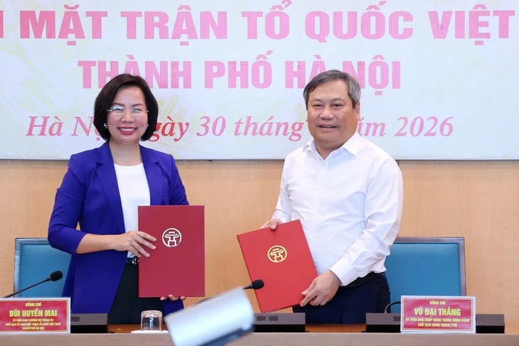 Chủ tịch Ủy ban nhân dân thành phố Hà Nội Vũ Đại Thắng trao biên bản bàn giao 18 hội cho Chủ tịch Ủy ban Mặt trận Tổ quốc Việt Nam thành phố Bùi Huyền Mai. Ảnh: Nhân Dân