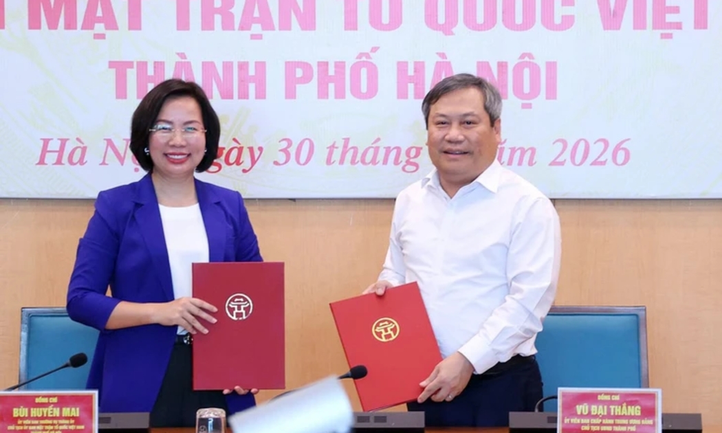 Chủ tịch Ủy ban nhân dân thành phố Hà Nội Vũ Đại Thắng trao biên bản bàn giao 18 hội cho Chủ tịch Ủy ban Mặt trận Tổ quốc Việt Nam thành phố Bùi Huyền Mai. Ảnh: Nhân Dân