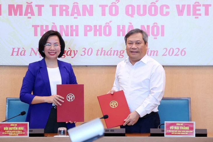 Chủ tịch Ủy ban nhân dân thành phố Hà Nội Vũ Đại Thắng trao biên bản bàn giao 18 hội cho Chủ tịch Ủy ban Mặt trận Tổ quốc Việt Nam thành phố Bùi Huyền Mai. Ảnh: Nhân Dân