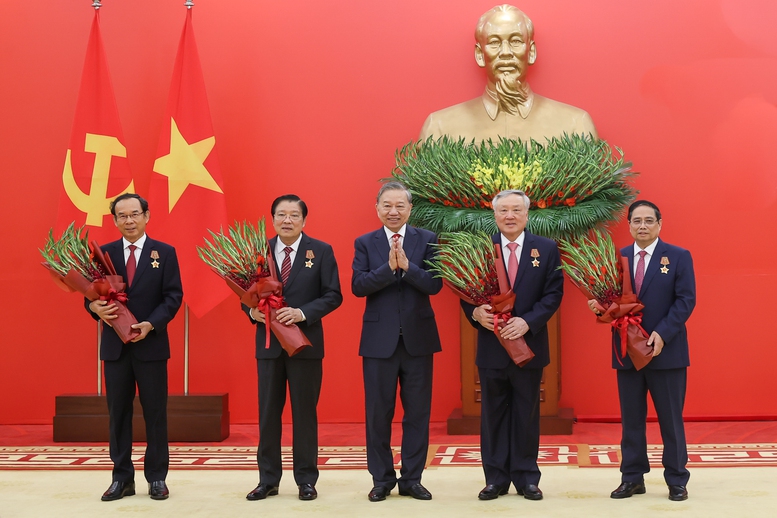 Tổng Bí thư Tô Lâm tặng hoa chúc mừng các đồng chí được nhận Huân chương Quân công hạng nhất - Ảnh: VGP