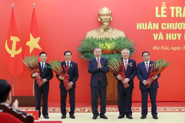 Tổng Bí thư Tô Lâm tặng hoa chúc mừng các đồng chí được nhận Huy hiệu Đảng - Ảnh: VGP