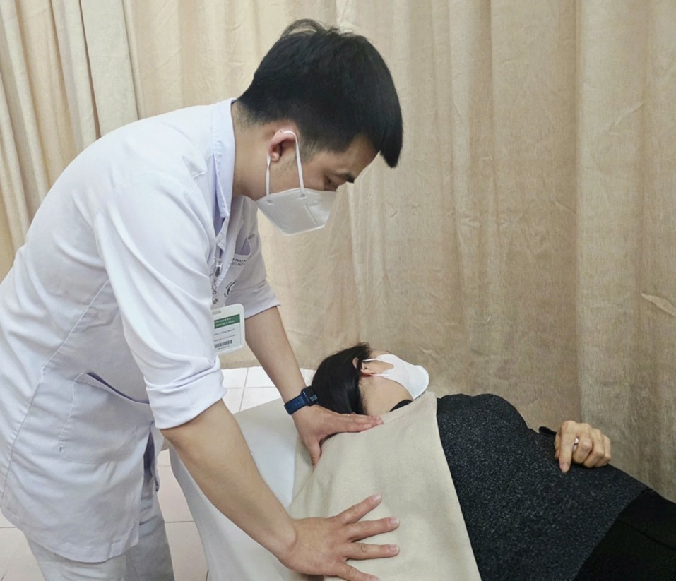 Bác sĩ bệnh viện Bạch Mai thực hiện phương pháp điều trị nhiệt - đắp parafin giảm đau, giãn cơ cho người bệnh.