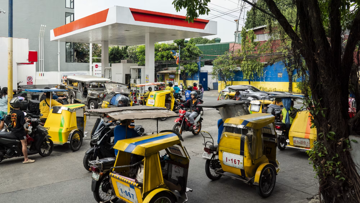 Xe ba bánh chở khách và xe máy xếp hàng tại một cây xăng ở Mandaluyong, Philippines, ngày 26/3 - Ảnh: Getty Images