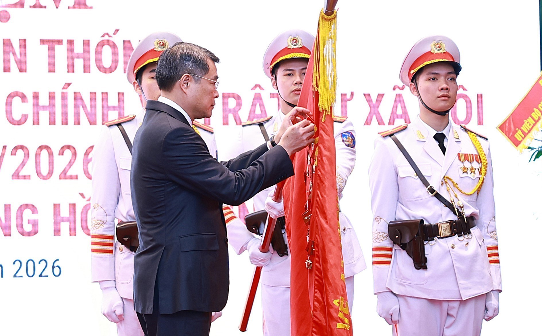 Thủ tướng Lê Minh Hưng gắn Huân chương Hồ Chí Minh lên Cờ truyền thống của lực lượng Cảnh sát Quản lý hành chính về trật tự xã hội. Ảnh: TTXVN