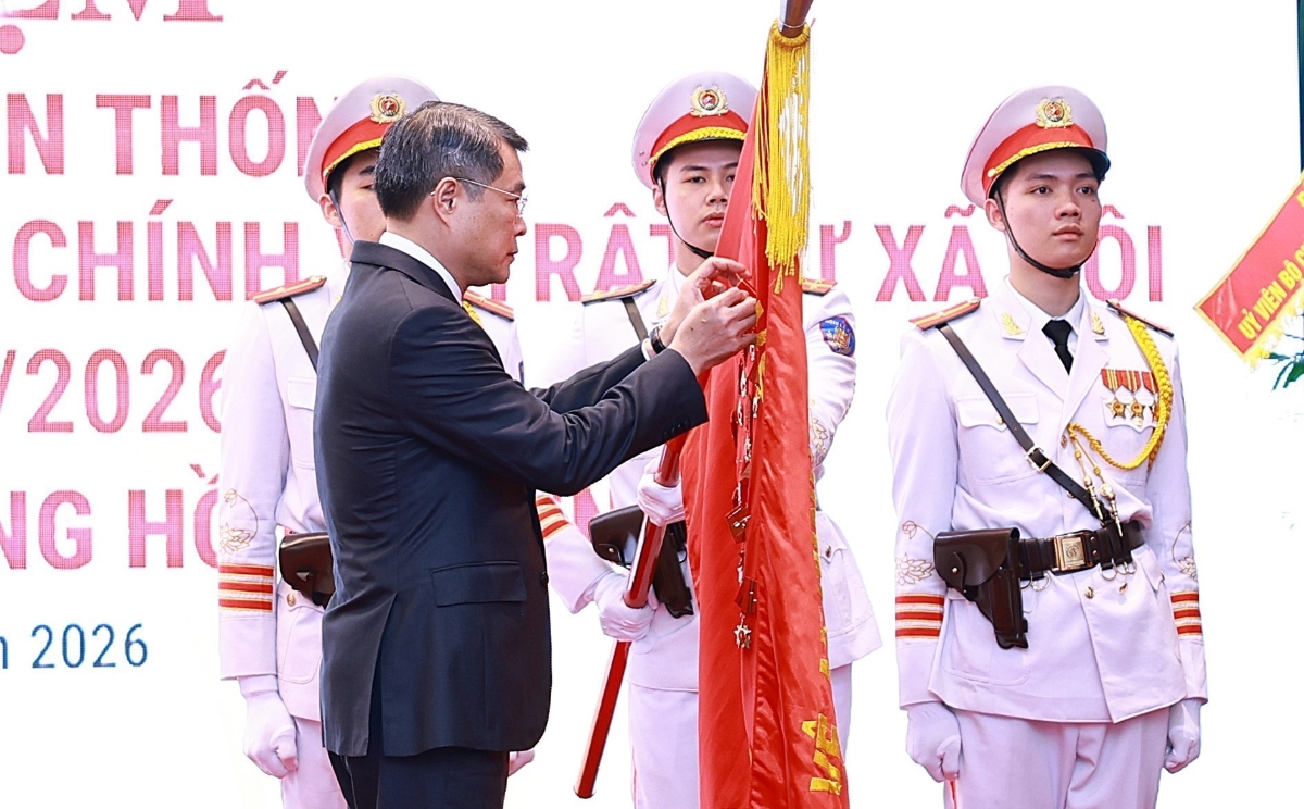 Thủ tướng Lê Minh Hưng gắn Huân chương Hồ Chí Minh lên Cờ truyền thống của lực lượng Cảnh sát Quản lý hành chính về trật tự xã hội. Ảnh: TTXVN
