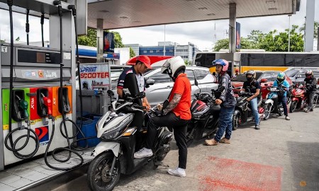 Nhân viên đổ xăng cho xe máy trong khi các tài xế xếp hàng tại một trạm xăng ở Quezon City, Metro Manila, Philippines. Ảnh: Reuters/Lisa Marie David
