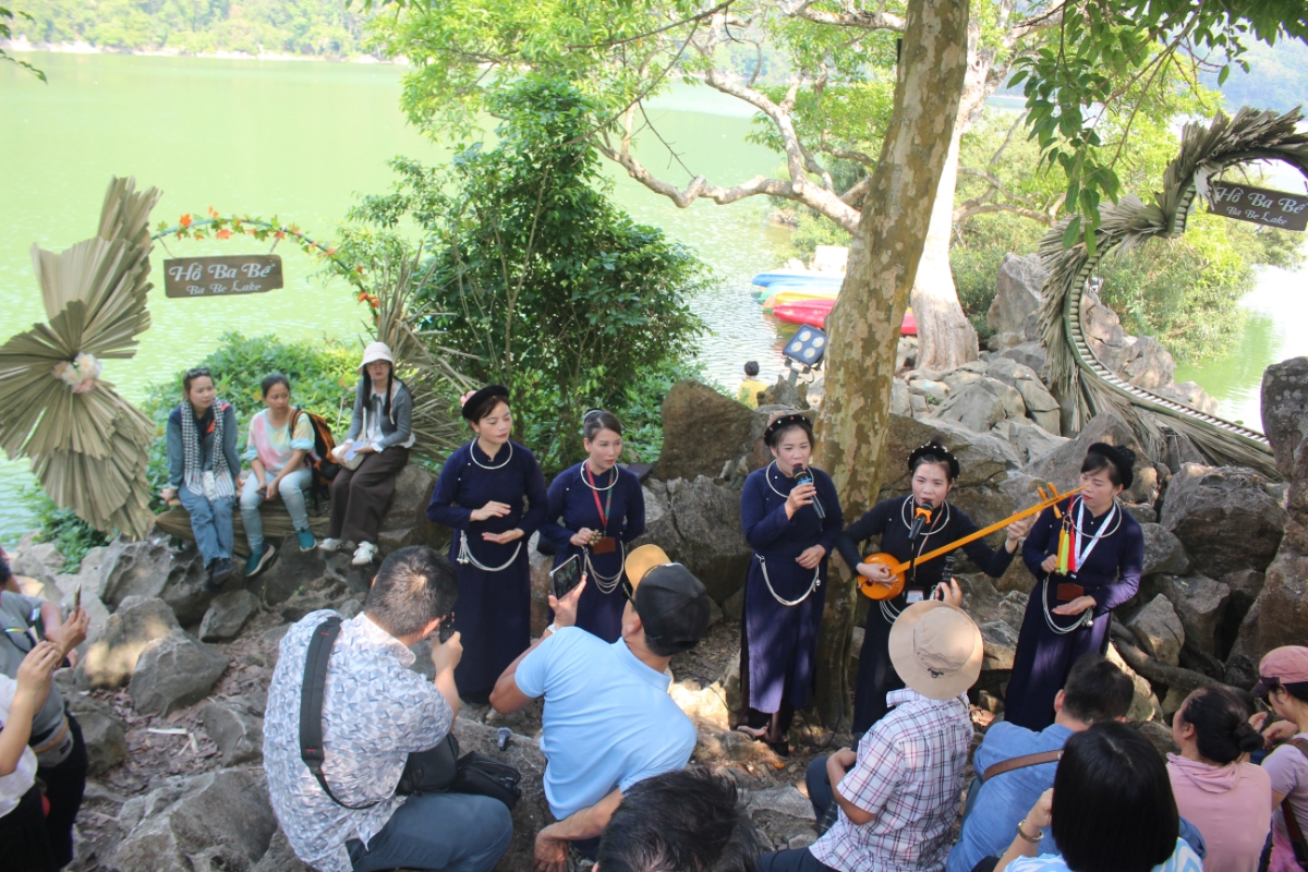 Đồng bào dân tộc Tày biểu diễn hát then trên một hòn đảo giữa Hồ Ba Bể. Ảnh: Chu Khôi.