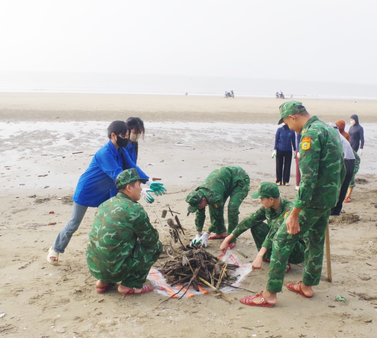 Đoàn viên thanh niên phối hợp cùng lực lượng chức năng khẩn trương dọn vệ sinh ven biển