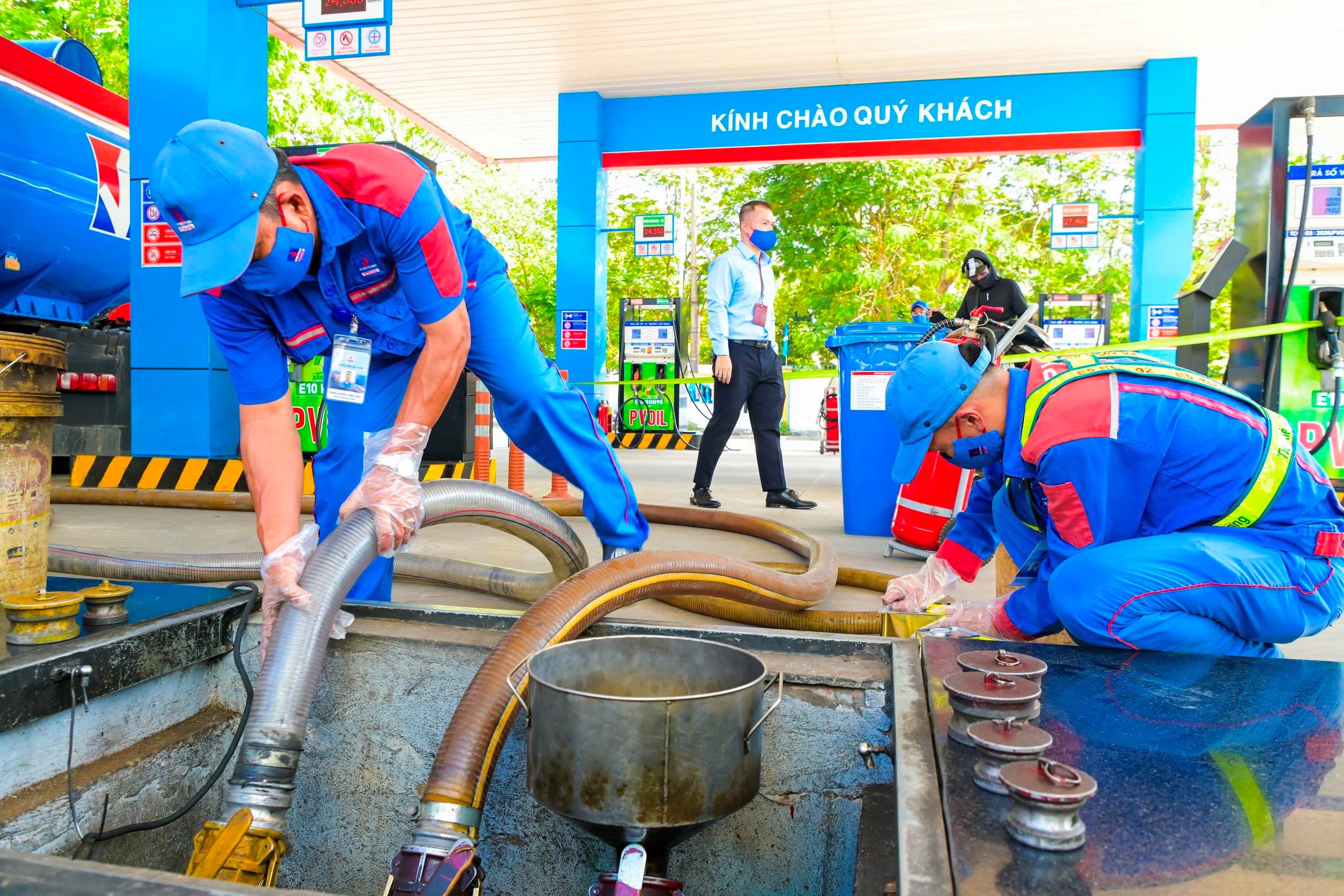 Nhân viên PVOIL nhập xăng E10 vào bồn chứa tại cửa hàng xăng dầu.