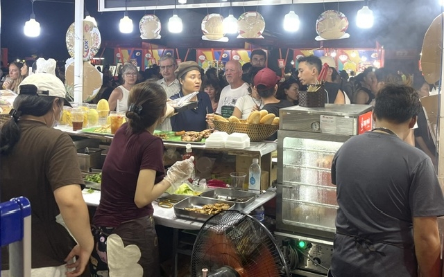 Đông đảo khách nước ngoài ưa thích món bánh mỳ kẹp thịt nướng xiên- đậm đà hương vị xứ Quảng. Ảnh Ngô Anh Văn