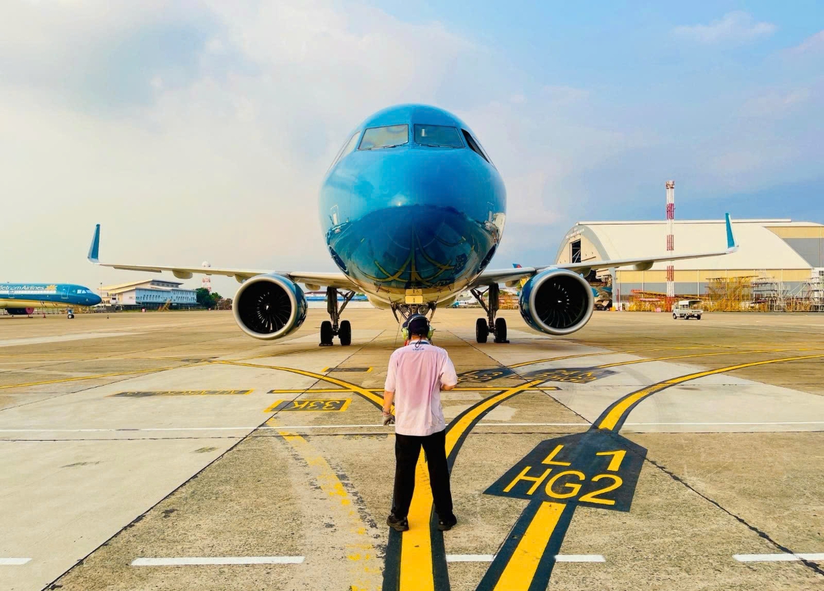 Những chiếc áo thấm đẫm mồ hôi nhưng vẫn không ngừng di chuyển trên sân đỗ. (Ảnh: VNA).