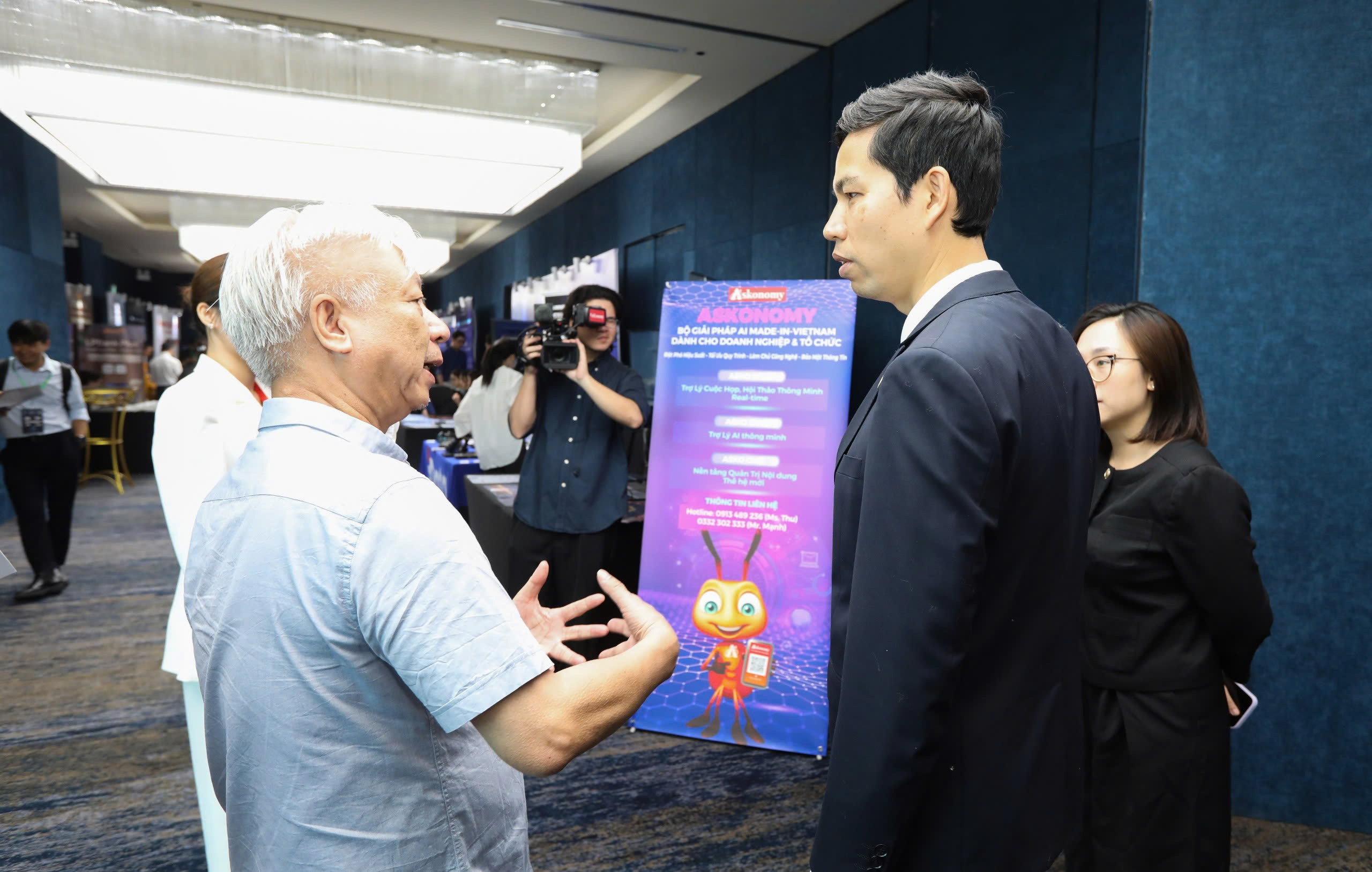 Mr. Dao Quang Binh (L), General Director, and Managing Editor of Vietnam Economic Times /VnEconomy, is sharing with Mr. Le Hong Quang, General Director of the MISA Group, about&nbsp;&nbsp;the made-in-Vietnam AI-powered solution Askonomy.- (Photo: Viet Dung)