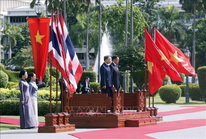 Tổng Bí thư, Chủ tịch nước Tô Lâm và Thủ tướng Thái Lan Anutin Charnvirakul trên bục danh dự, nghe Quân nhạc cử Quốc thiều hai nước. Ảnh: TTXVN