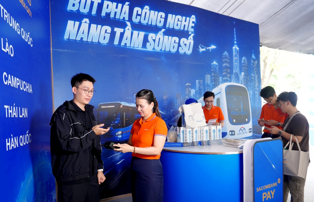 Một du khách Trung Quốc (góc trái) trải nghiệm dịch vụ thanh toán VIETQRGlobal ngay trên app Alipay tại gian hàng SACOMBANK sáng 6/6 - Ảnh: SACOMBANK.
