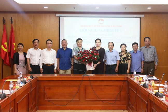 Bà Hà Thị Nga - Ủy viên Trung ương Đảng, Phó Chủ tịch - Tổng Thư ký Ủy ban Trung ương Mặt trận Tổ quốc Việt Nam tặng hoa chúc mừng nhóm đề tài. Ảnh: Mặt trận.