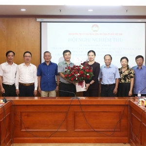 Bà Hà Thị Nga - Ủy viên Trung ương Đảng, Phó Chủ tịch - Tổng Thư ký Ủy ban Trung ương Mặt trận Tổ quốc Việt Nam tặng hoa chúc mừng nhóm đề tài. Ảnh: Mặt trận.