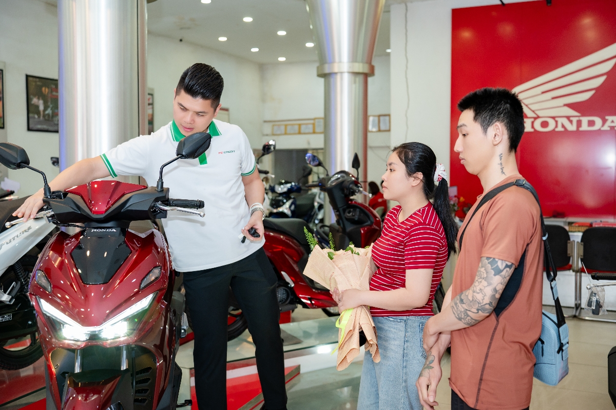 Đại diện FE CREDIT trao xe máy đến vợ chồng chị Huế Trân. Ảnh: FE CREDIT.