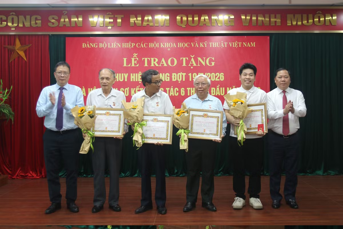 Đồng chí Châu Văn Minh và đồng chí Nguyễn Phi Long trao huy hiệu Đảng cho các đảng viên. Ảnh: Mai Loan