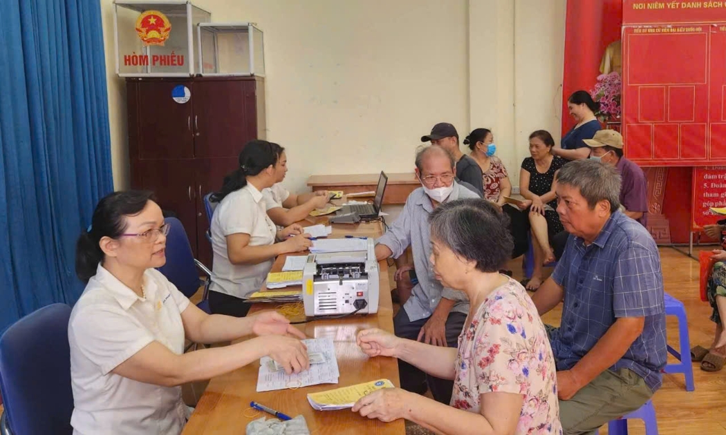 Người hưởng nhận chế độ liên quan đến bảo hiểm xã hội tại Hà Nội. Ảnh: T.H.