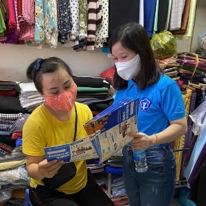 Cán bộ Bảo hiểm xã hội tư vấn chế độ về bảo hiểm cho chủ hộ kinh doanh. Ảnh: Nguyễn Duy.