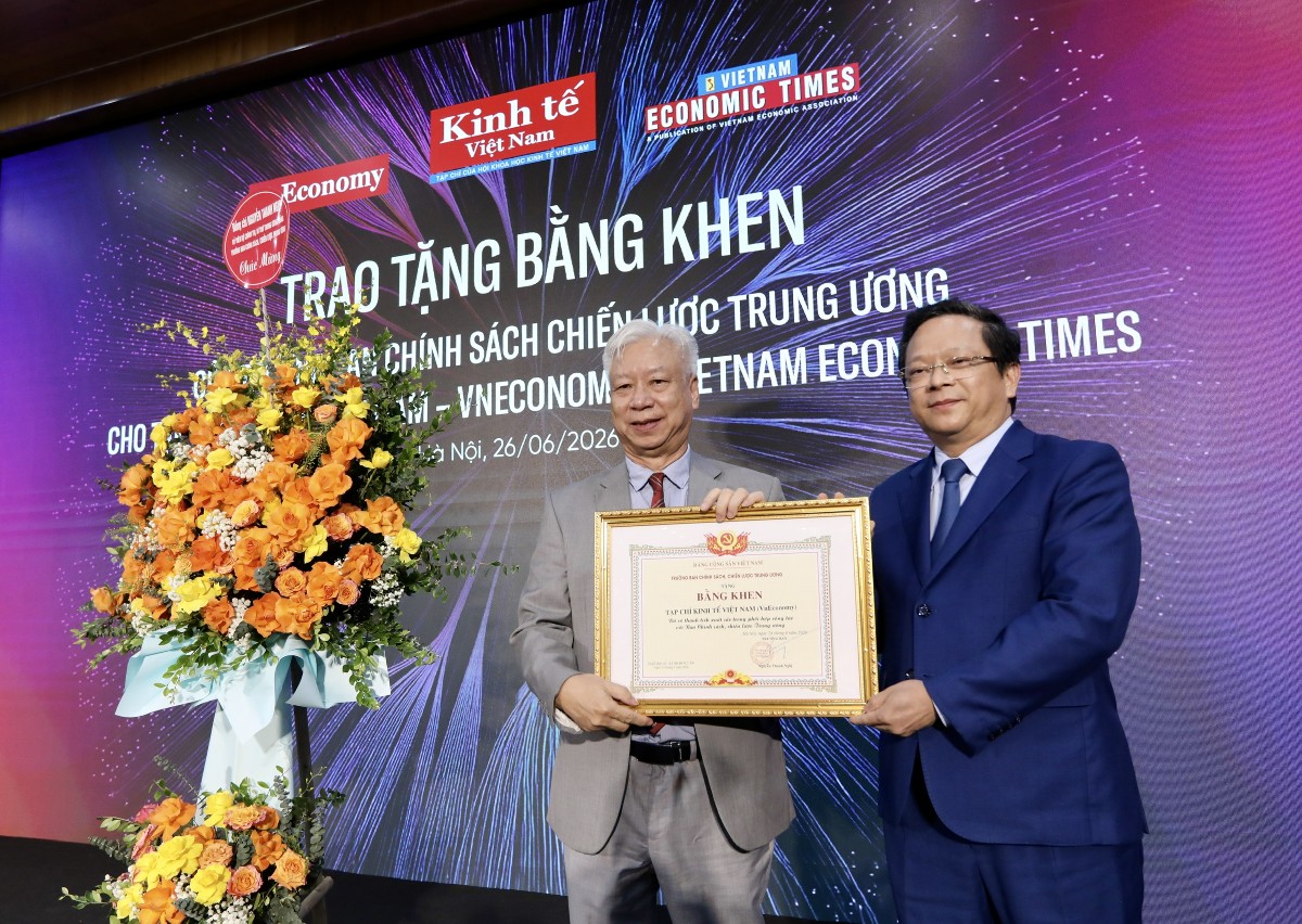 Thừa ủy quyền của TS. Nguyễn Thanh Nghị, Ủy viên Bộ Chính trị, Bí thư Trung ương Đảng, Trưởng Ban Chính sách, Chiến lược Trung ương, TS. Nguyễn Đức Hiển, Phó Trưởng Ban Chính sách, Chiến lược Trung ương (người bên phái), đã trao lẵng hoa chúc mừng và Bằng khen của Trưởng ban Chính sách, Chiến lược Trung ương cho đại diện lãnh đạo Tạp chí Kinh tế Việt Nam/VnEconomy, ông Đào Quang Bính - Phó Chủ tịch Hội đồng biên tập, Tổng giám đốc, Tổng Thư ký tòa soạn. Ảnh: Trí Phong.