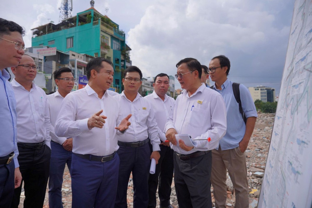 Chủ tịch UBND Thành phố Nguyễn Văn Được (giữa) trao đổi với đơn vị thi công trình bày phương án thi công của công trình - Ảnh: Cổng thông tin điện tử TP. Hồ Chí Minh