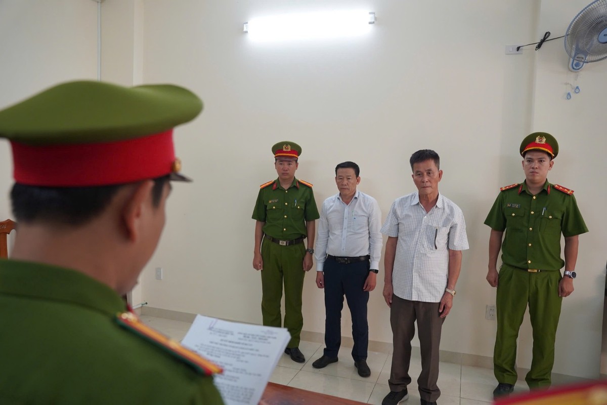 Cơ quan Cảnh sát điều tra Công an tỉnh tống đạt các quyết định đối với Trần Huỳnh Kiến Trúc (áo trắng) và Đỗ Ngọc Quang (áo ca rô). Ảnh: Cổng thông tin điện tử Bộ Công an.