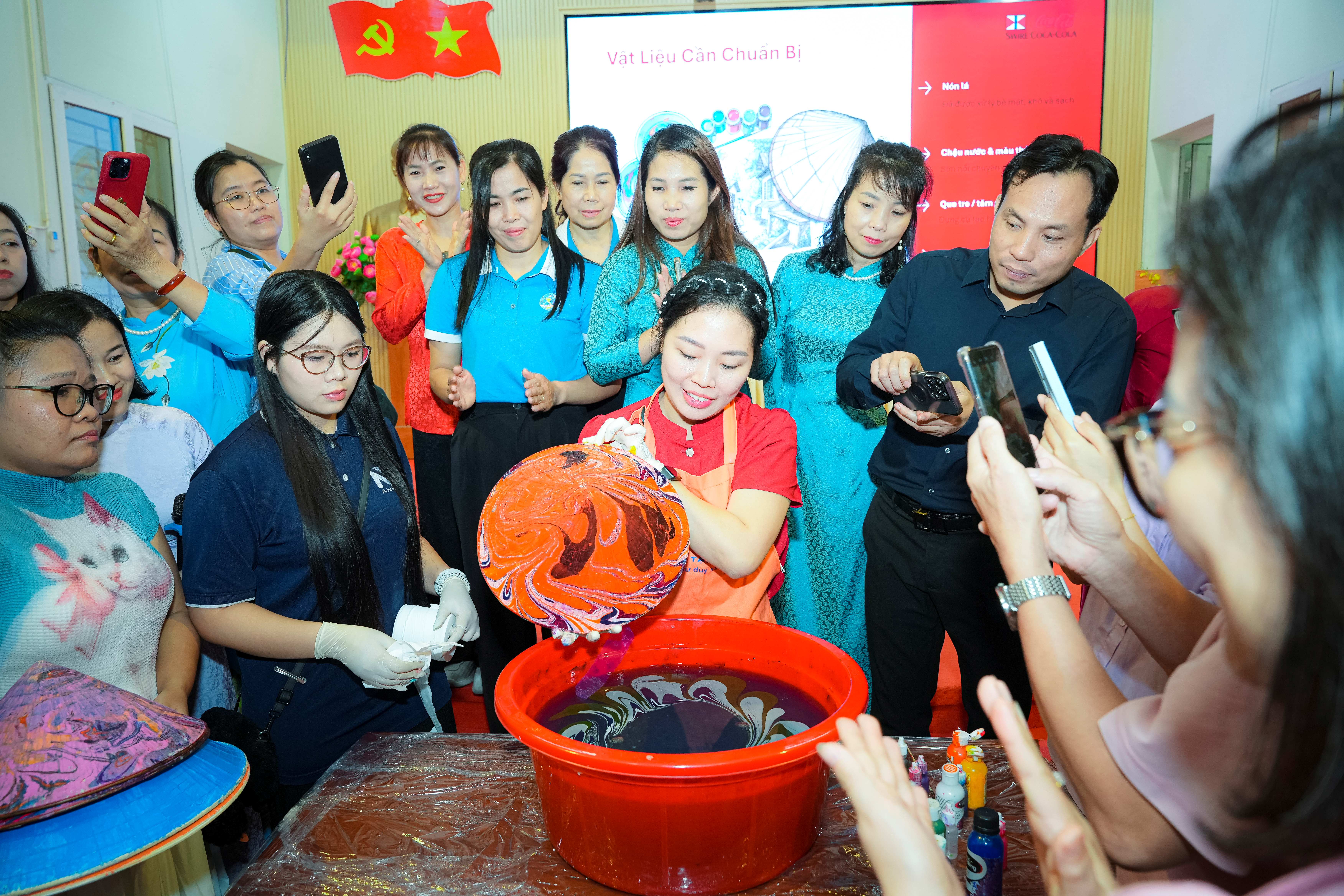 A lecturer in Arts and Design from the School of Interdisciplinary Sciences and Arts, Vietnam National University, Hanoi, demonstrates hydro-dipping techniques for decorating traditional Vietnamese conical hats.