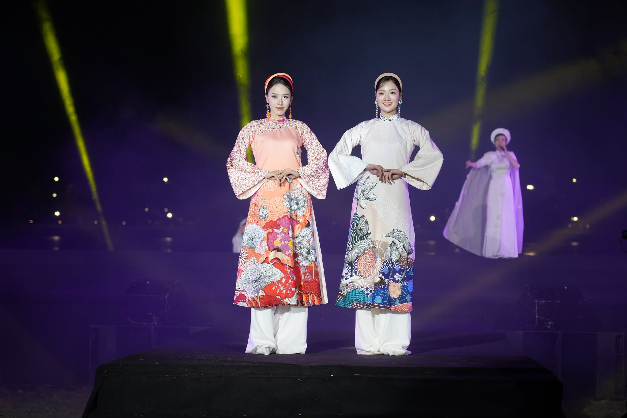 Người mẫu sải bước giữa sân khấu ngoài trời, tôn vinh vẻ đẹp thanh lịch của áo dài.