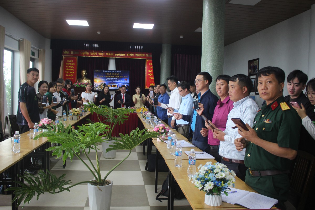 Các đại biểu thao tác bình chọn Tà Xùa trên điện thoại. Ảnh: Chu Khôi.