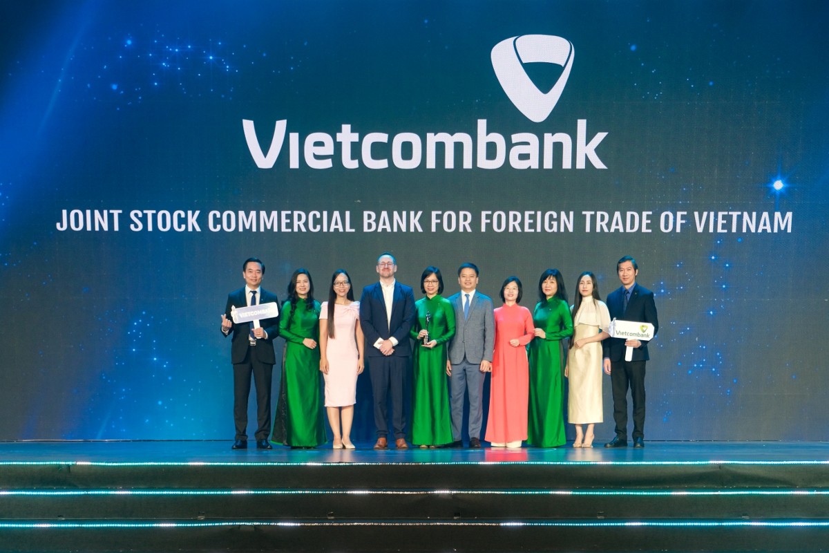 Bà Tô Thị Phương Dung - Trưởng Phòng Chính sách & Kế hoạch nhân sự đại diện Vietcombank nhận cúp "Harmonia" từ Ban tổ chức và đại diện lãnh đạo các đơn vị Vietcombank tham dự sự kiện. Ảnh: VCB.