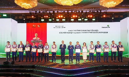 Đồng chí Nguyễn Thanh Tùng - Bí thư Đảng ủy, Chủ tịch HĐQT Vietcombank (thứ 8 từ phải sang) tặng giấy khen và đ/c Lê Quang Vinh - Phó Bí thư Đảng ủy, Thành viên HĐQT, Tổng Giám đốc Vietcombank (thứ 9 từ phải sang) trao hoa chúc mừng cho 15 chi nhánh tiêu biểu trong hoạt động kinh doanh 6 tháng đầu năm 2026. Ảnh: Vietcombank.