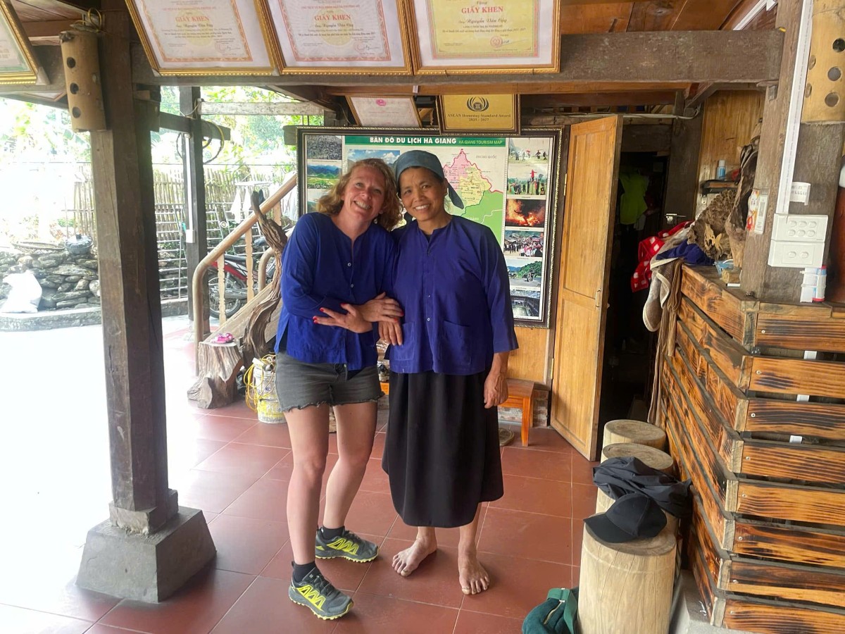 Một du khách nước ngoài chụp ảnh cùng một chủ homestay ở thôn Tha. Ảnh: Chu Khôi.