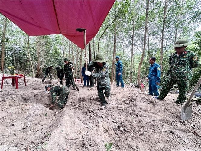 Các thành viên Đội K51 Đắk Lắk và các lực lượng cẩn thận đào từng lớp đất để tìm kiếm, quy tập hài cốt liệt sĩ trong Chiến dịch 500 ngày đêm. Ảnh: TTXVN.