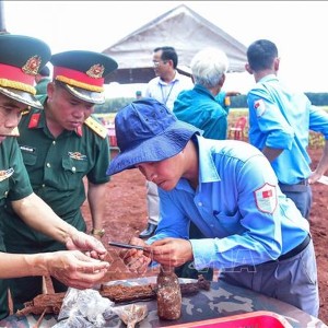 Tại hiện trường, lực lượng chức năng đã phát hiện nhiều di vật, gồm một khẩu súng AK, sáu cây bút (gồm một bút mực, bốn bút bi và một bút chì), hai bình tông, bốn đôi dép, bốn chiếc răng, một đoạn dây đai lưng cùng nhiều hiện vật khác. Ảnh: TTXVN.