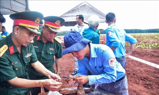 Tại hiện trường, lực lượng chức năng đã phát hiện nhiều di vật, gồm một khẩu súng AK, sáu cây bút (gồm một bút mực, bốn bút bi và một bút chì), hai bình tông, bốn đôi dép, bốn chiếc răng, một đoạn dây đai lưng cùng nhiều hiện vật khác. Ảnh: TTXVN.