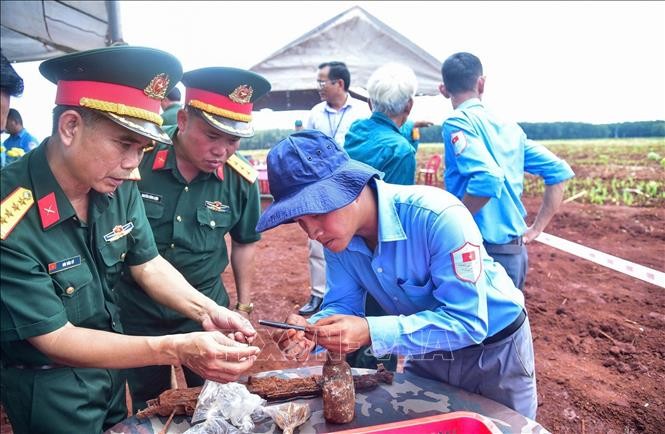 Tại hiện trường, lực lượng chức năng đã phát hiện nhiều di vật, gồm một khẩu súng AK, sáu cây bút (gồm một bút mực, bốn bút bi và một bút chì), hai bình tông, bốn đôi dép, bốn chiếc răng, một đoạn dây đai lưng cùng nhiều hiện vật khác. Ảnh: TTXVN.