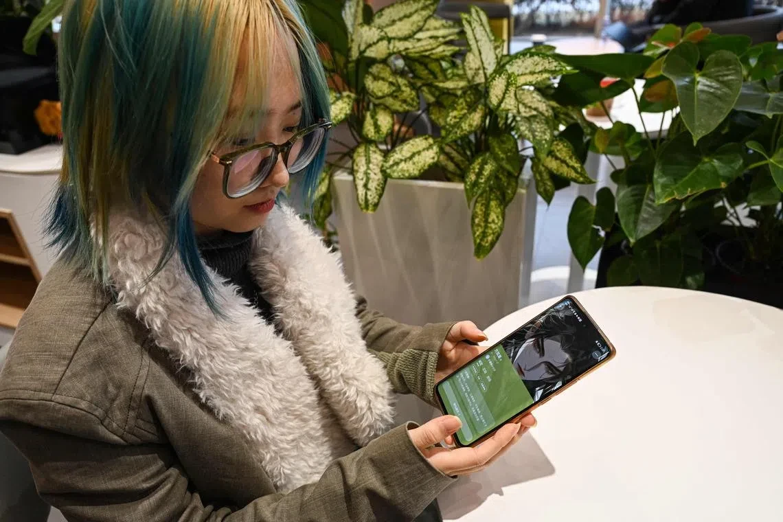 Wang Xiuting đang giới thiệu "bạn trai ảo" của mình, một chatbot trí tuệ nhân tạo trên ứng dụng Wantalk, do công ty công nghệ Baidu của Trung Quốc tạo ra. Ảnh: Straits Times