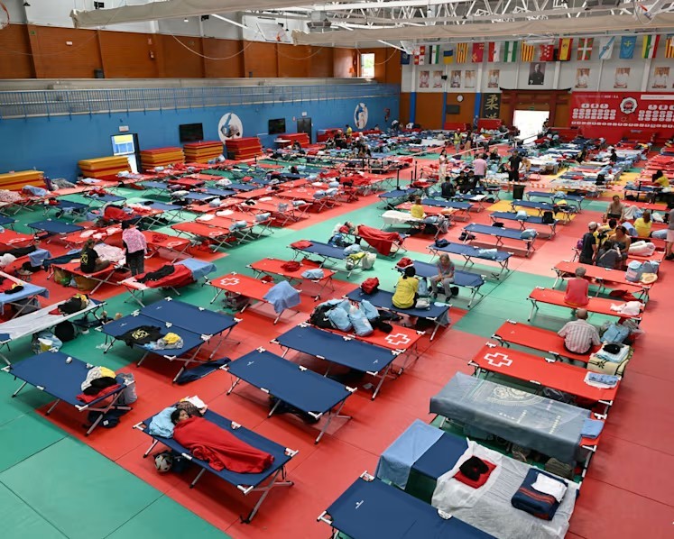 Người dân sơ tán nghỉ ngơi trong một nhà thi đấu tại Villaviciosa de Odon, cách Madrid khoảng 20 km về phía tây, sau khi các vụ cháy rừng thiêu rụi tới 25.000 ha đất. Ảnh: AFP/Javier Soriano