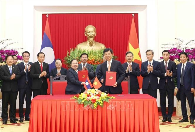 Trưởng Ban Tổ chức Trung ương Nguyễn Duy Ngọc và Trưởng Ban Tổ chức Trung ương Đảng Nhân dân Cách mạng Lào Sisay Leudetmounsone trao Thoả thuận hợp tác giữa hai cơ quan. Ảnh: Phương Hoa - TTXVN