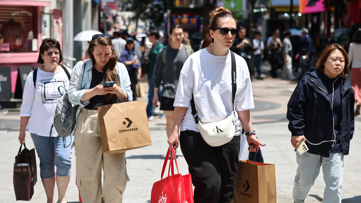 Du khách nước ngoài shopping trên phố Myeongdong, quận Jung-gu, Seoul, ngày 13/7. Ảnh: News1