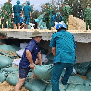 Các lực lượng khẩn trương gia cố, khắc phục sạt lở trên tuyến đường bê tông ven biển nối bãi tắm Thuận An với bãi tắm Phú Thuận, phường Thuận An. Ảnh: CSCC