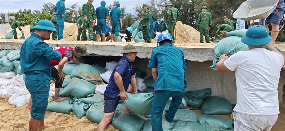 Các lực lượng khẩn trương gia cố, khắc phục sạt lở trên tuyến đường bê tông ven biển nối bãi tắm Thuận An với bãi tắm Phú Thuận, phường Thuận An. Ảnh: CSCC