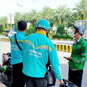 Tài xế công nghệ trong giờ nghỉ trưa khi làm việc ngoài trời. Ảnh: Thu Hằng.