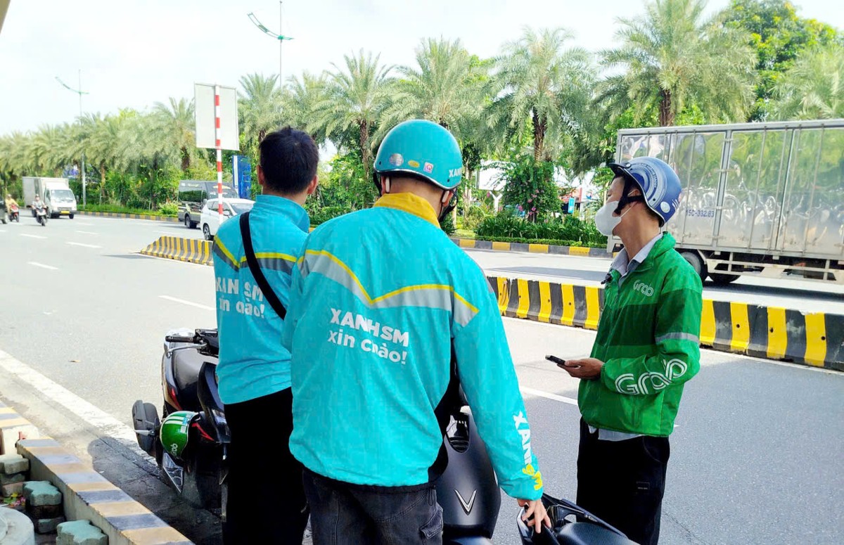 Tài xế công nghệ trong giờ nghỉ trưa khi làm việc ngoài trời. Ảnh: Thu Hằng.