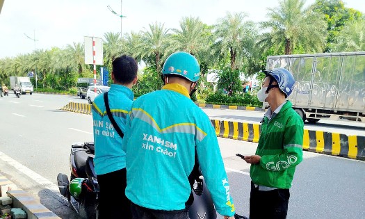 Tài xế công nghệ trong giờ nghỉ trưa khi làm việc ngoài trời. Ảnh: Thu Hằng.